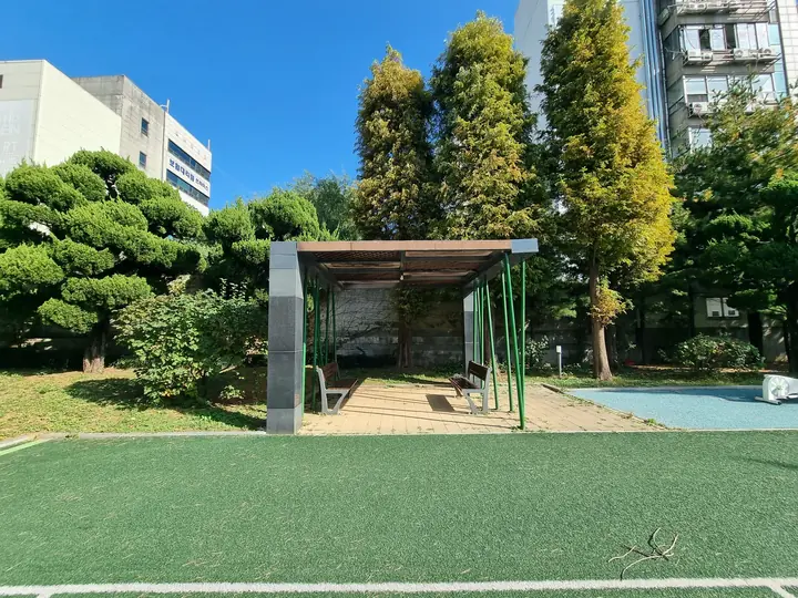 인조잔디 옆 목조 그늘막 쉼터