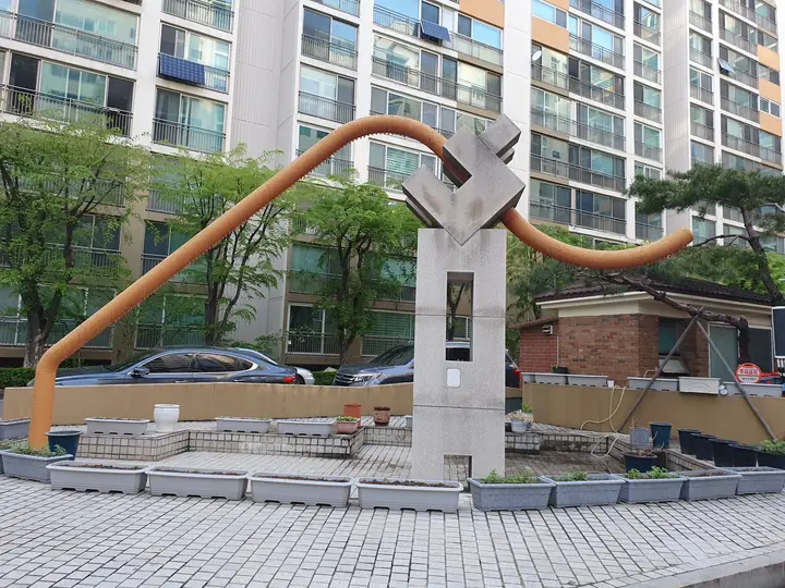 곡선 파이프를 얹은 광장 조형물