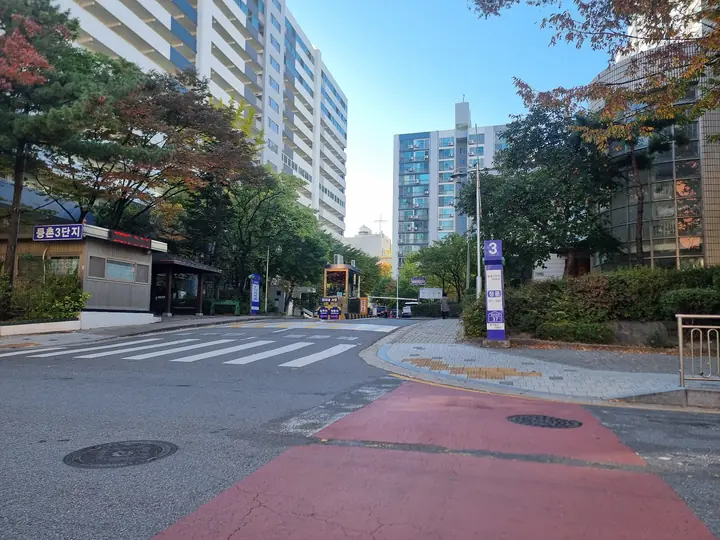 경비실과 '3' 기둥 안내판이 선 정문 진입로