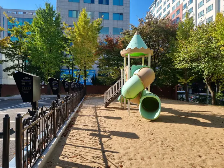 철제 울타리를 두른 모래 놀이터