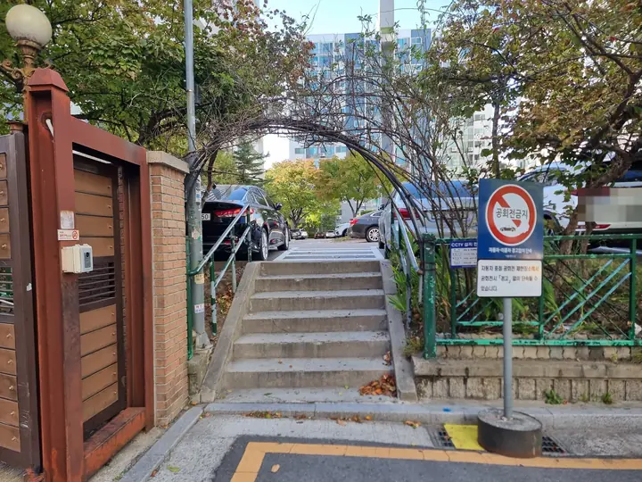 넝쿨 아치와 계단이 이어진 보행 쪽문