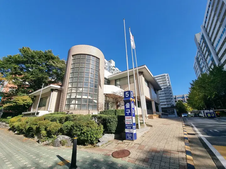 '5 출구' 표지판 옆 원통형 유리창 관리동