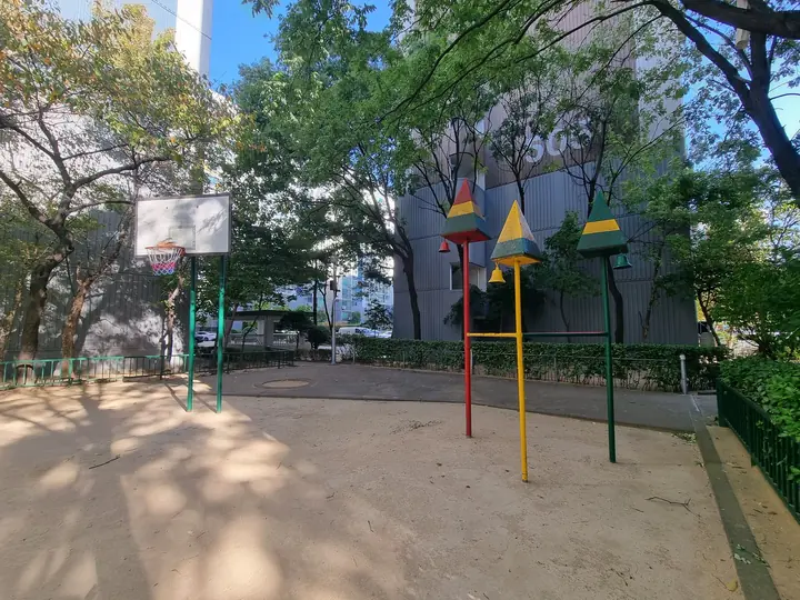 농구대와 고깔 모양 기둥이 선 흙 운동장