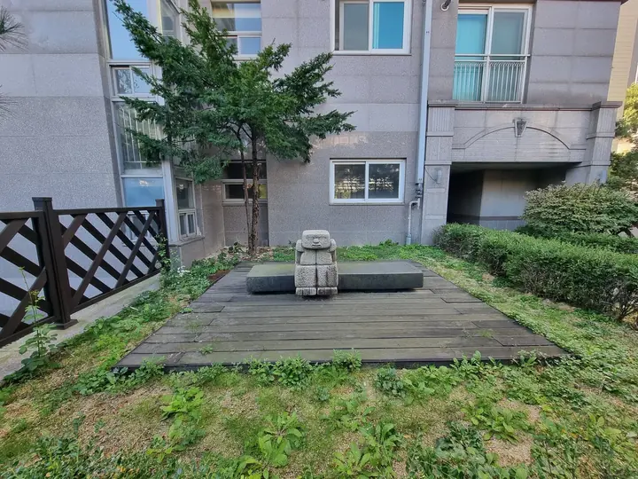 석상을 놓은 동 앞 데크 정원