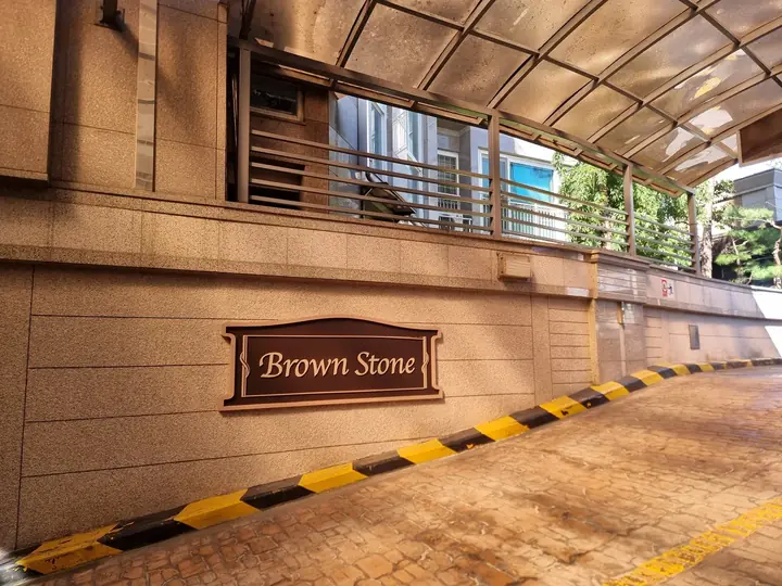 'Brown Stone' 명판을 단 지하주차장 진입로