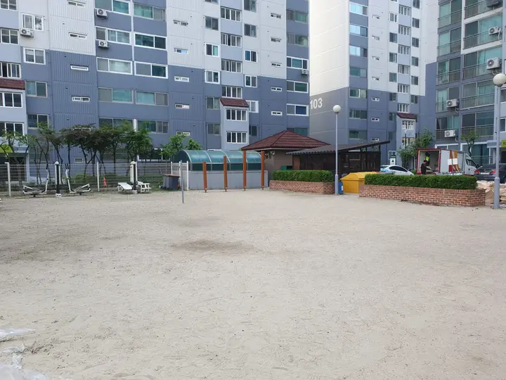 동 앞에 펼쳐진 넓은 모래 마당