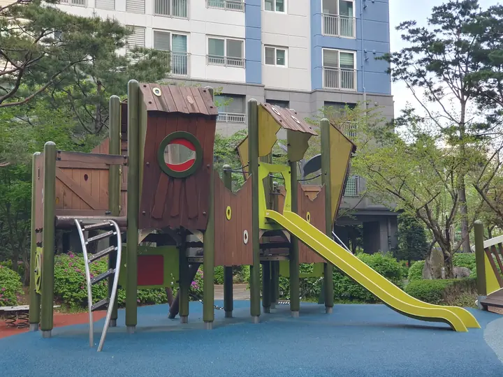 노란 미끄럼틀이 있는 목재 놀이대