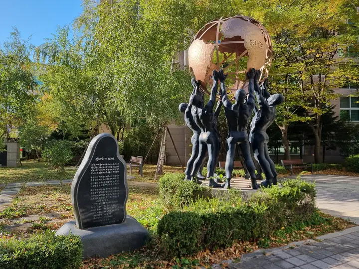 지구를 떠받친 사람들 조형물과 글귀 비석