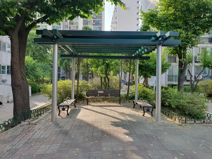 나무 그늘 아래 퍼걸러 쉼터