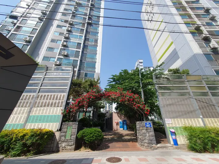 장미 아치 너머로 솟은 고층 동