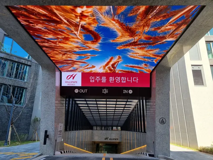 '입주를 환영합니다' LED 천장을 단 지하주차장 진입로