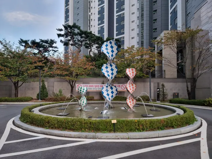 지하주차장 입구 앞 원형 분수와 조형물