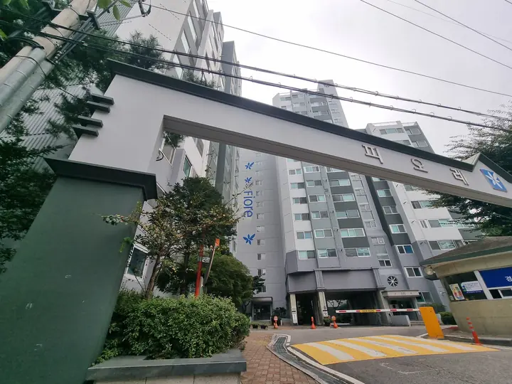 문주 기둥 너머 'Fiore' 동과 진입로