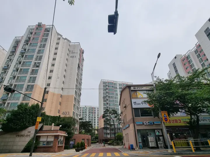 경비실과 '수명산파크 4단지' 문주가 있는 정문, 길 건너 상가