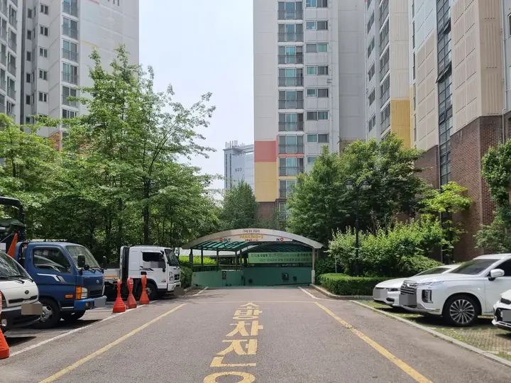 지상 주차 구역을 지나 이어지는 지하주차장 진입로