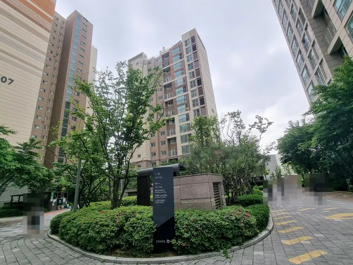 관리사무소·커뮤니티 방향 안내판이 선 원형 화단
