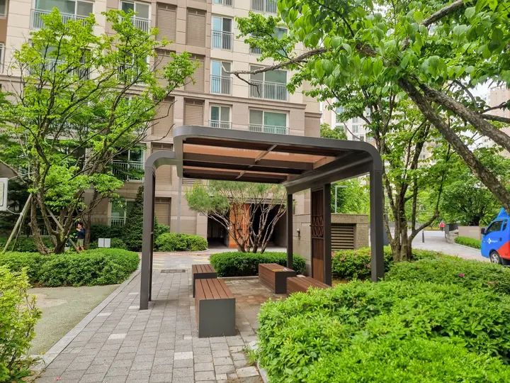 목재 퍼걸러와 벤치가 놓인 쉼터
