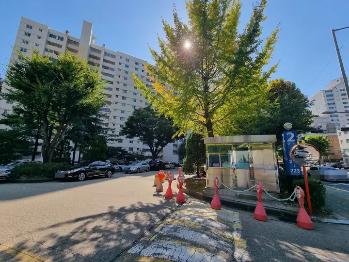 경비실과 차단 콘을 둔 차량 출입구