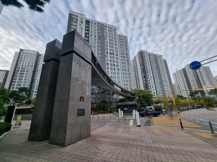 227번지 주소판이 붙은 문주 기둥과 고층 동