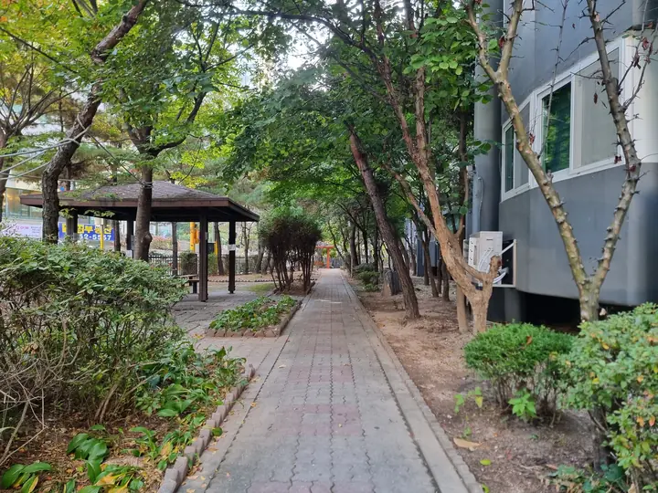 동 옆 나무 사이로 난 산책로와 정자