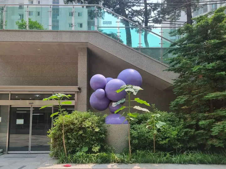 보라색 구슬 조형물이 있는 커뮤니티동 입구