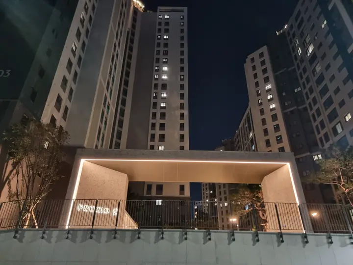 난간 너머로 올려다본 정문 게이트와 고층 동