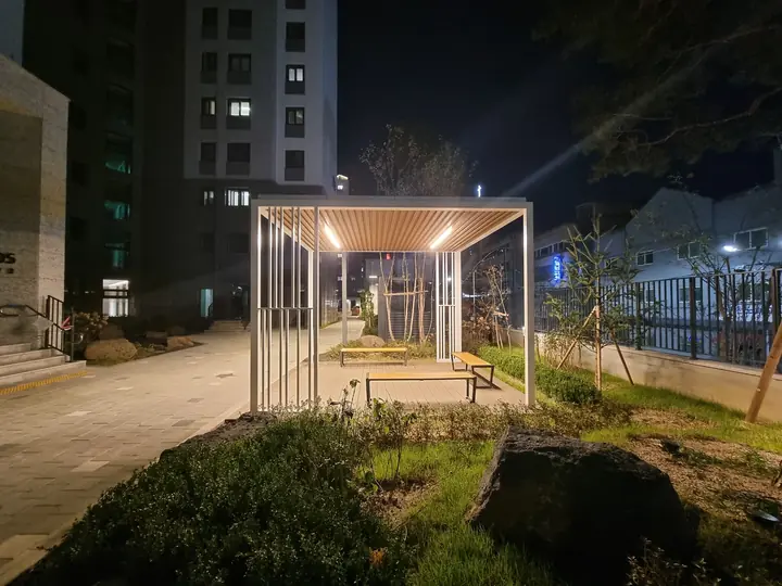 정원 옆 조명이 켜진 그늘막 쉼터