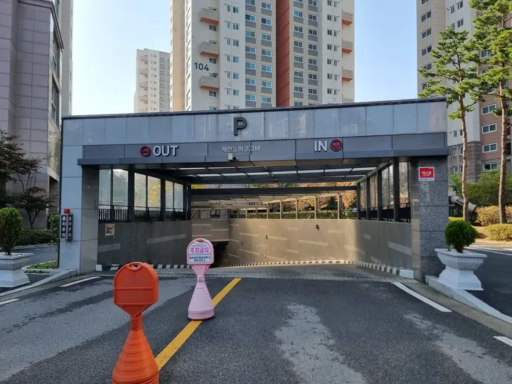 'OUT·IN' 표지가 달린 지하주차장 입구