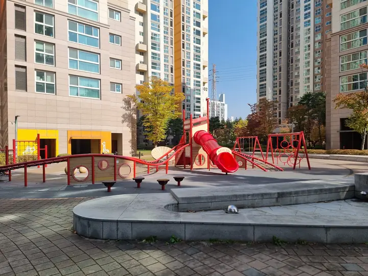 빨간 미끄럼틀과 그네가 있는 놀이터