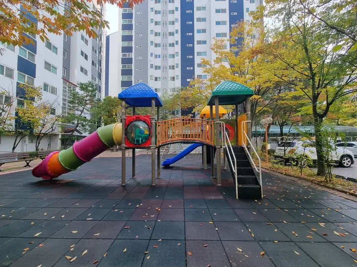 파란 지붕과 터널 미끄럼틀이 있는 놀이터