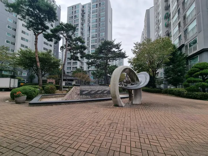 소나무 사이 원형 광장의 고리 모양 조형물