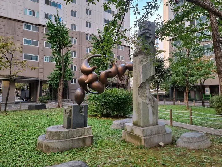 잔디밭의 청동 조형물과 돌기둥