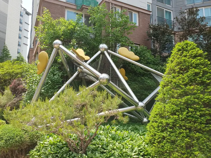 향나무 사이 구 조형물