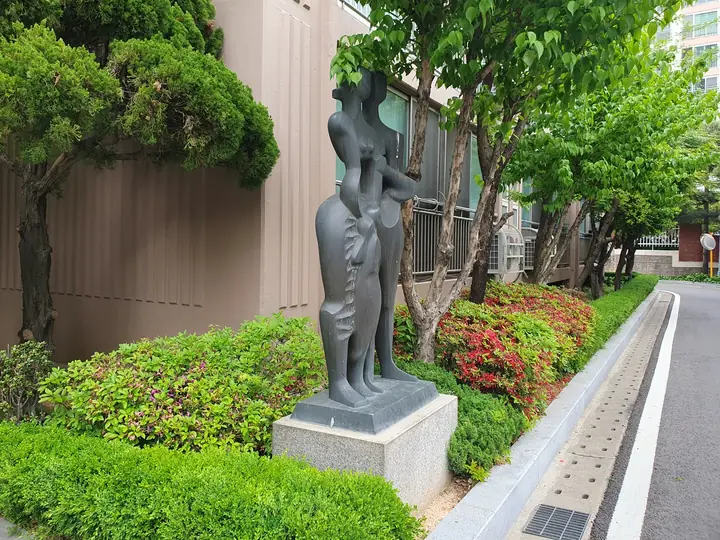 철쭉 화단의 가족 조각상